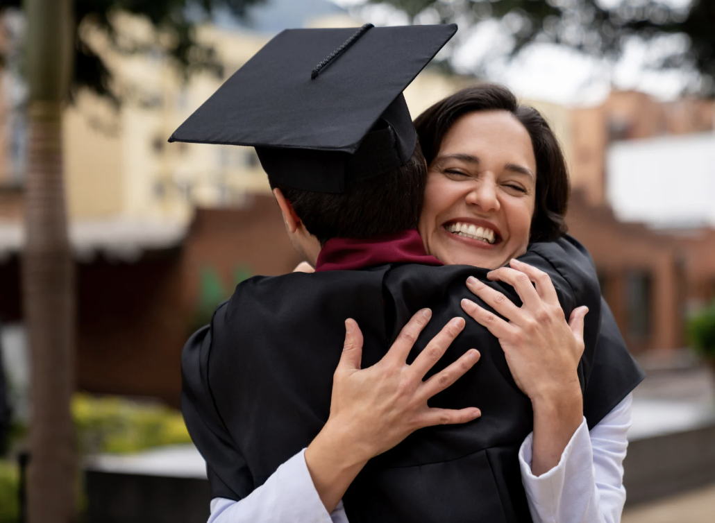 Proud mother hugging her high school graduate son.