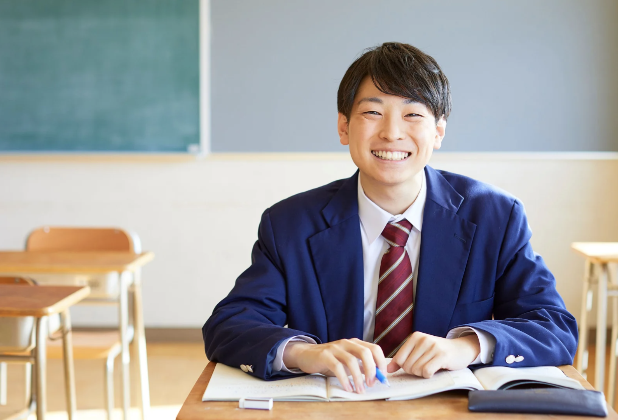 High school student boy in private school uniform smiles at camera.